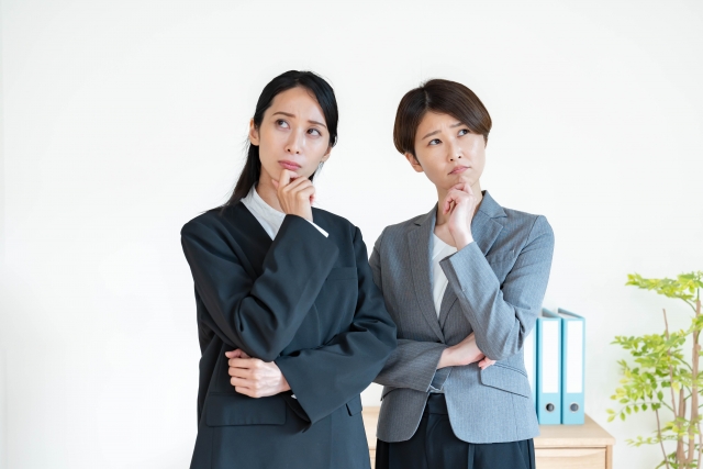 考えるスーツを着た2人の女性