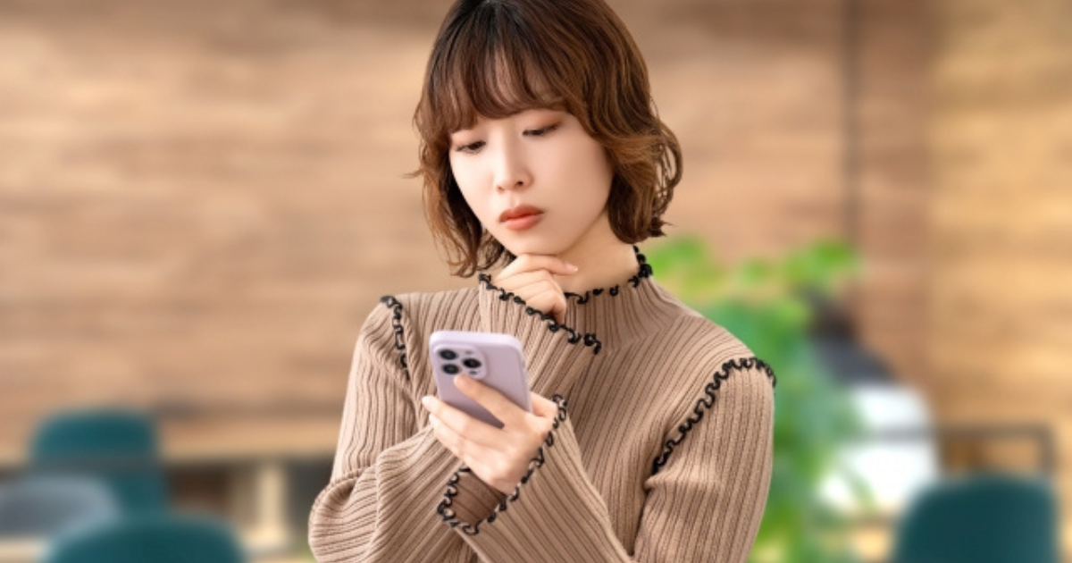 スマホを眺めて考えているビジネスパーソン